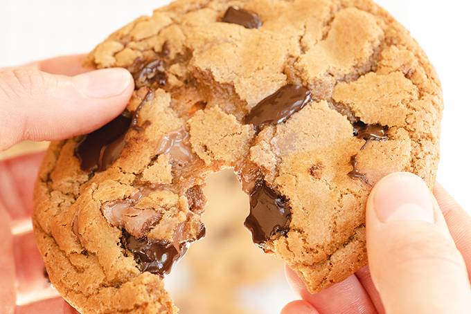 Close up of a chocolate chip cookie being split in half