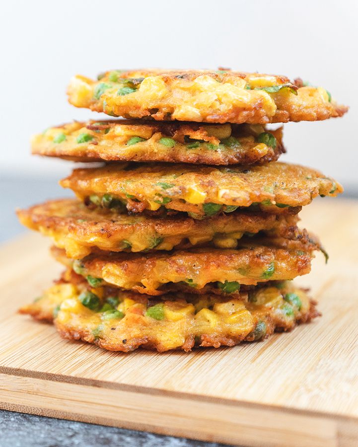 A stack of fried vegetable fritters on a wooden board
