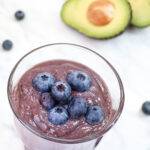 Close up of a glass of blueberry avocado smoothie