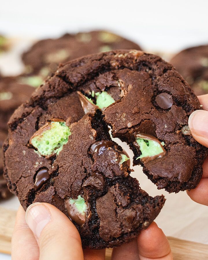 Close up of an aero mint chocolate chip cookie being broken in half.