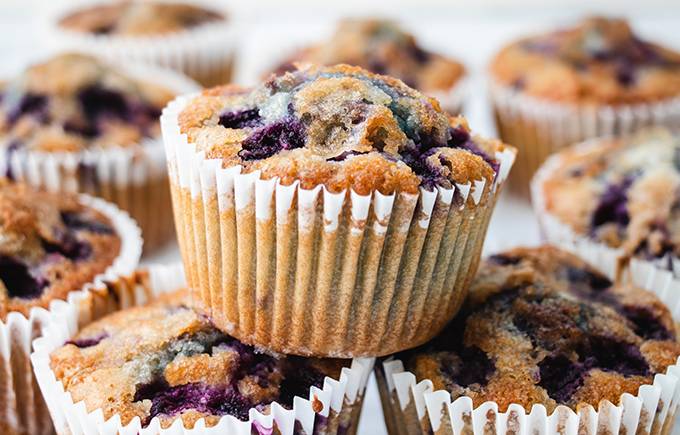 Close up of a gluten free blueberry muffin stacked on top of two other muffins