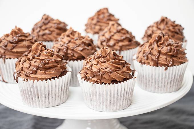 Gluten free nutella filled cupcakes on a white cake stand.