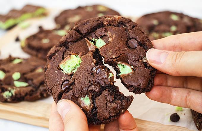 Close up of an aero mint chocolate chip cookie being broken in half.