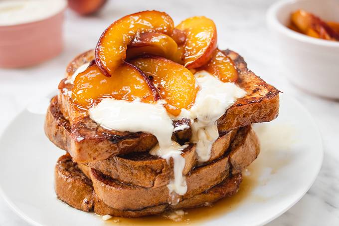 A plate of French toast topped with caramelised peaches and yoghurt