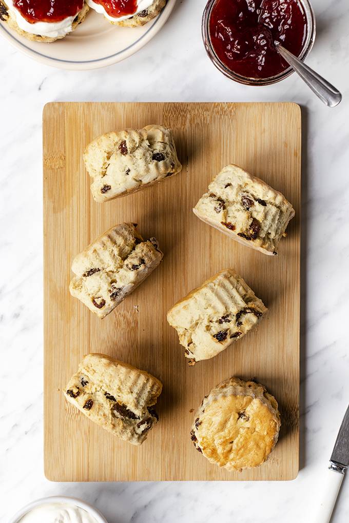 Gluten and dairy free sultana scones laid out on a wooden board.