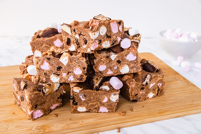 A stack of Kinder rocky road bars on a wooden board.