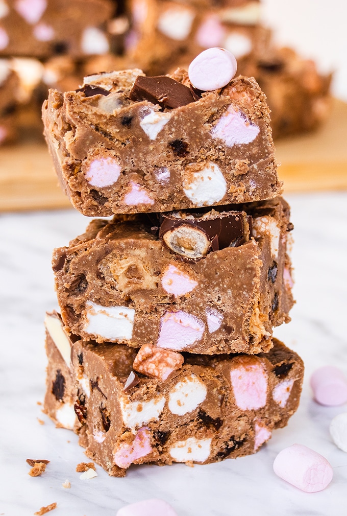 Close up of a stack of three Kinder rocky road bars with some mini marshmallows scattered around it.