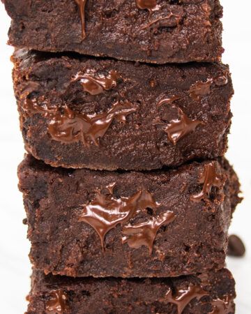 Close up of a stack of gooey vegan date brownies.