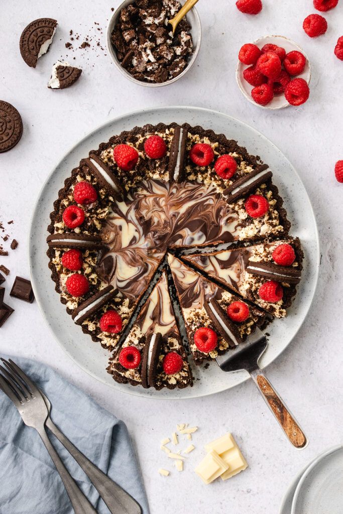 Top down view of a chocolate Oreo tart, decorated with raspberries.