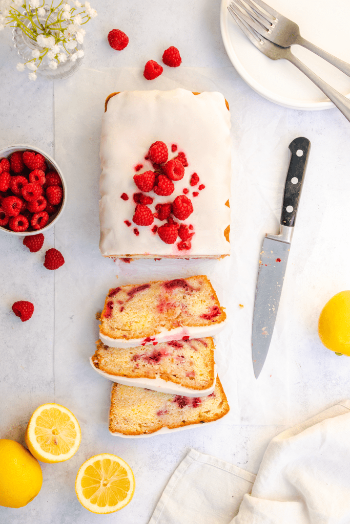 Top down view of a raspberry and lemon loaf cake, cut into slices.