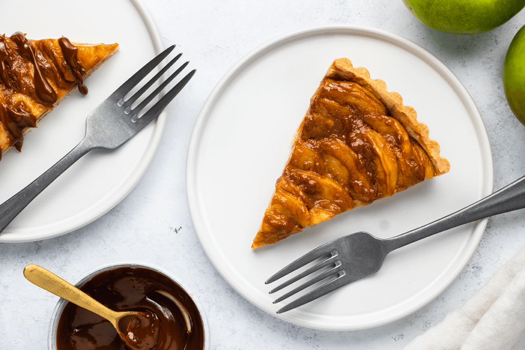 Top down view of a slice of caramel apple tart on a plate