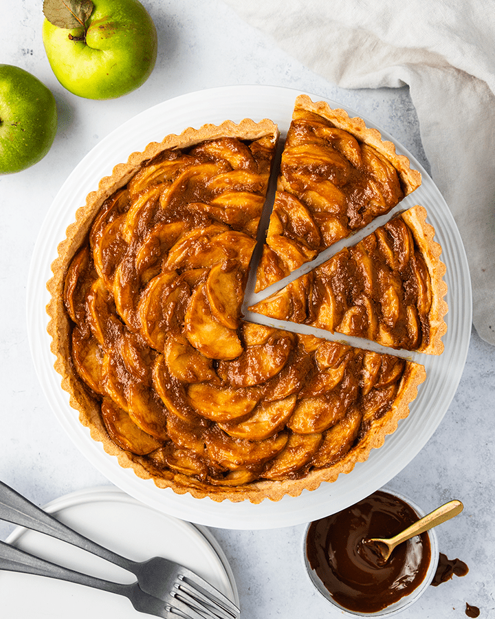 Top down view of a toffee apple tart on a cake stand